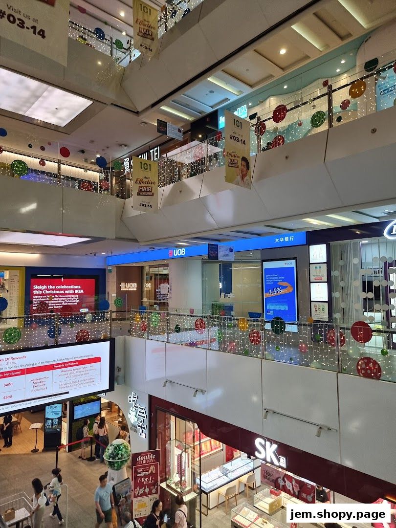 A multi-level shopping mall interior with various shops and festive decorations.