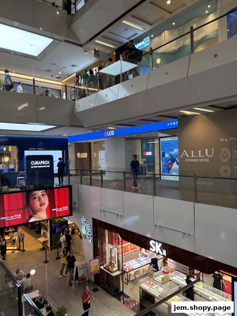 Interior view of a shopping mall with various shops including UOB bank and SK jewelry.