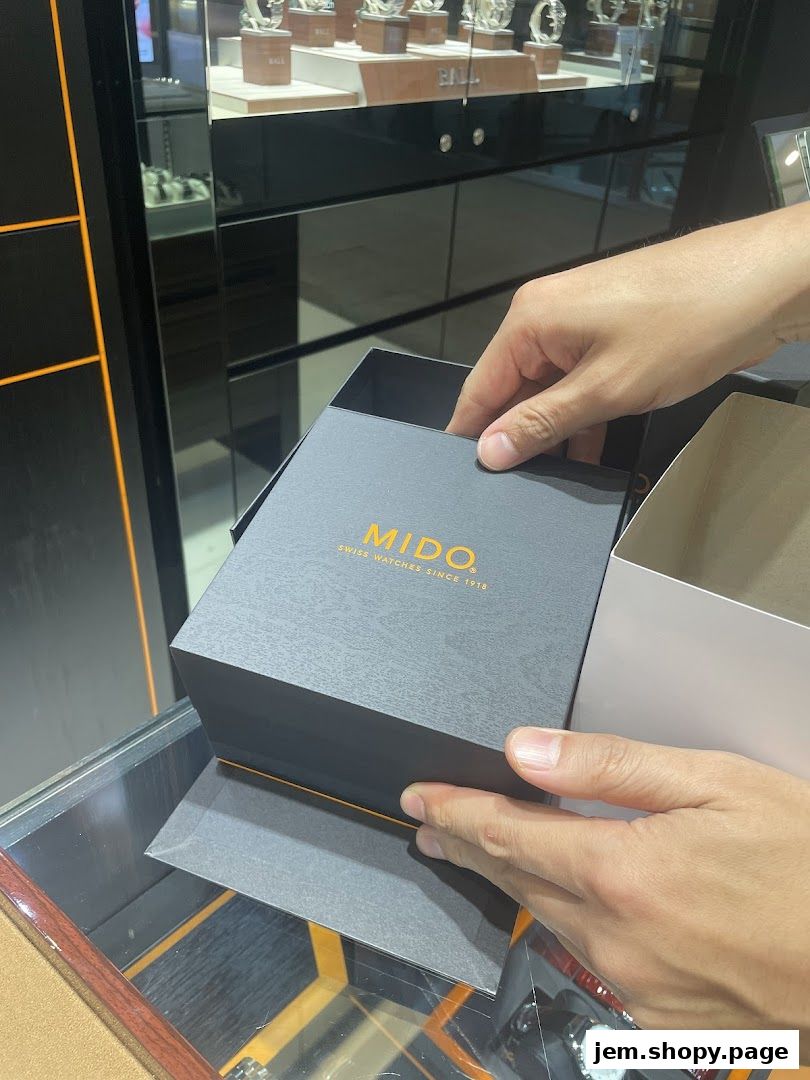 Hands opening a Mido watch box inside a luxury watch store.