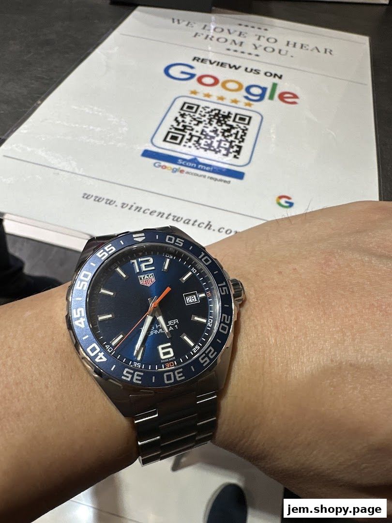 A TAG Heuer Formula 1 watch is displayed on a wrist with a Google review sign in the background.