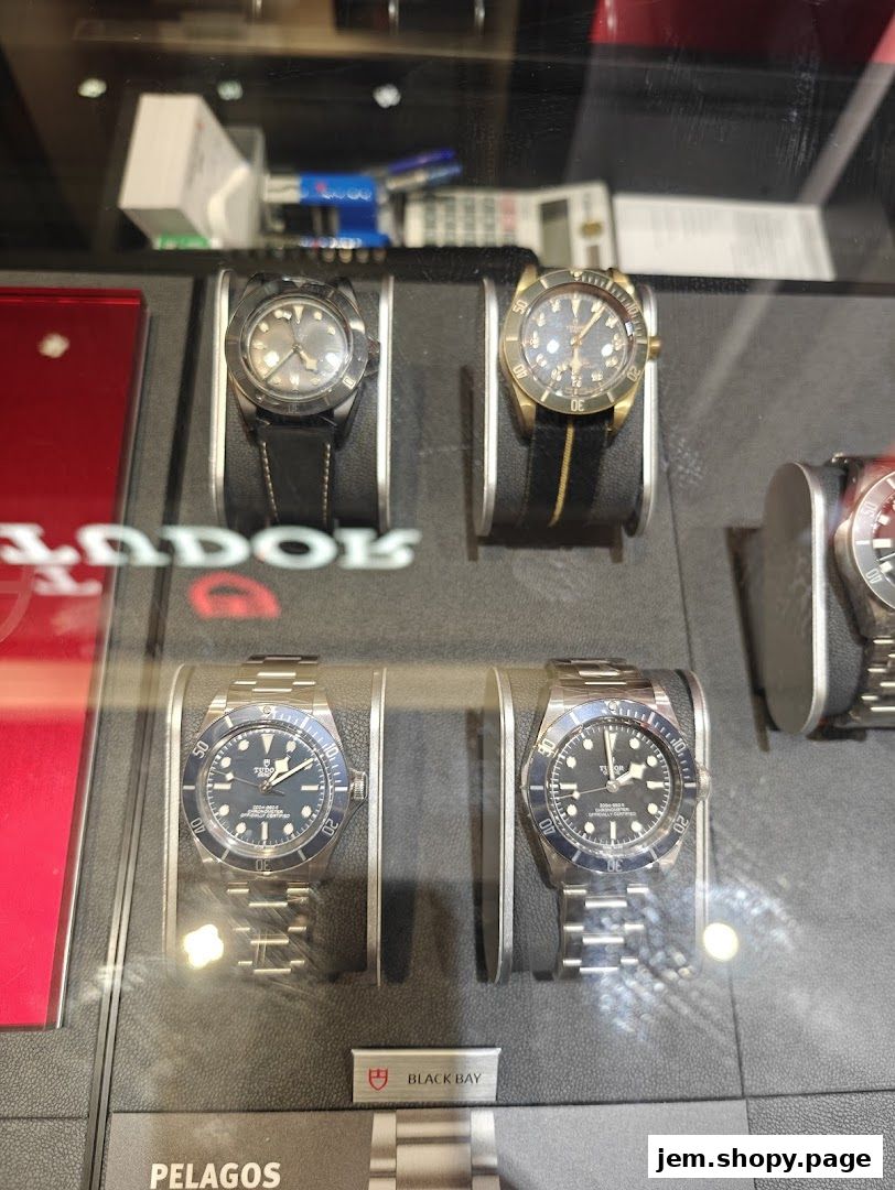 Display of luxury Tudor and Longines watches in a retail store window.