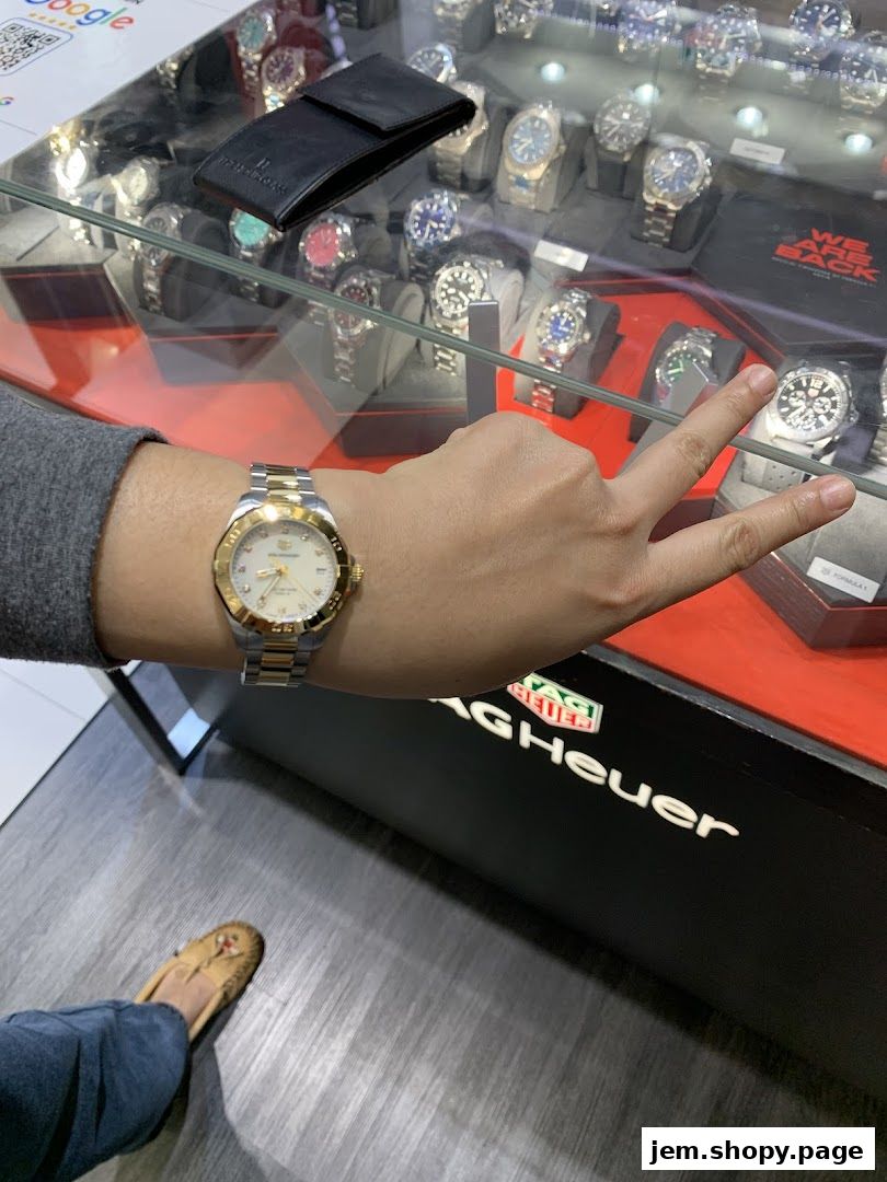 A person wearing a watch in a luxury watch store display.