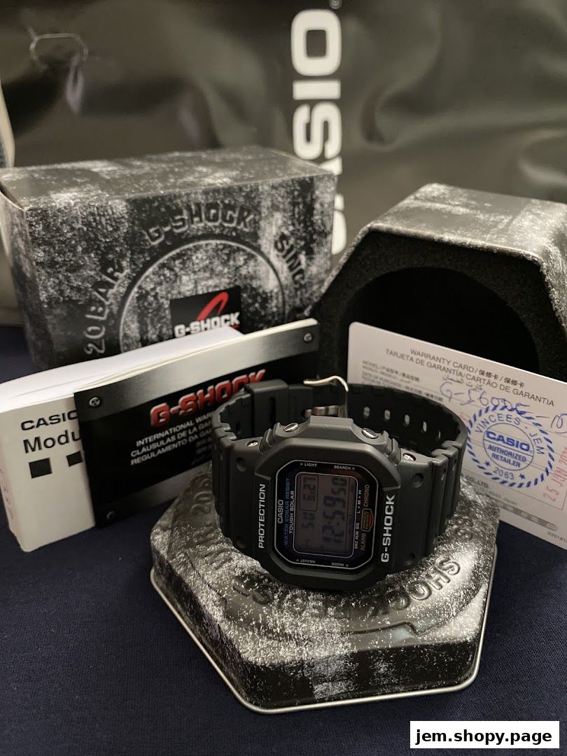 A black G-Shock watch with its packaging and warranty card.