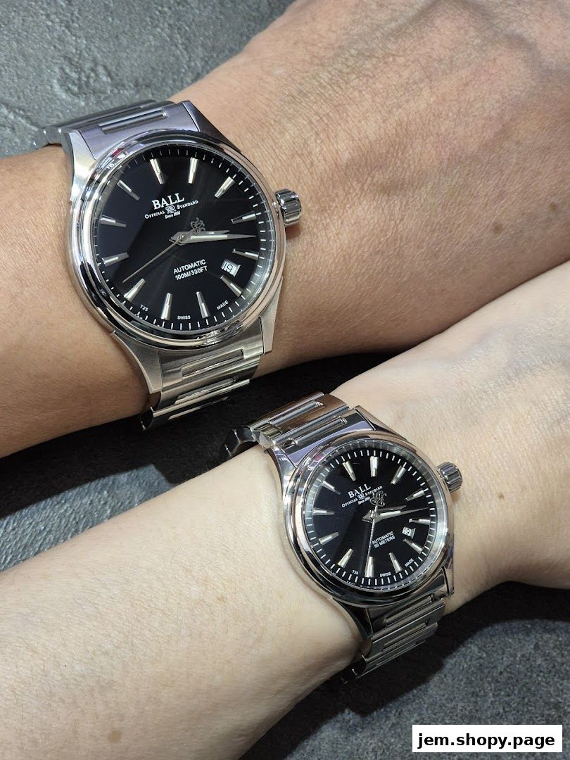 Two wrists wearing matching stainless steel automatic watches with black faces.