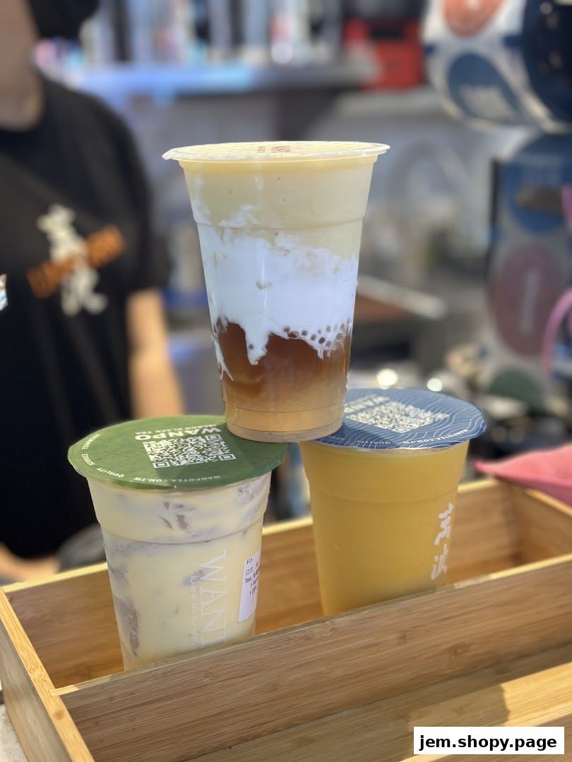 Three layered drinks from Wanpo Tea Shop are displayed in a wooden tray.