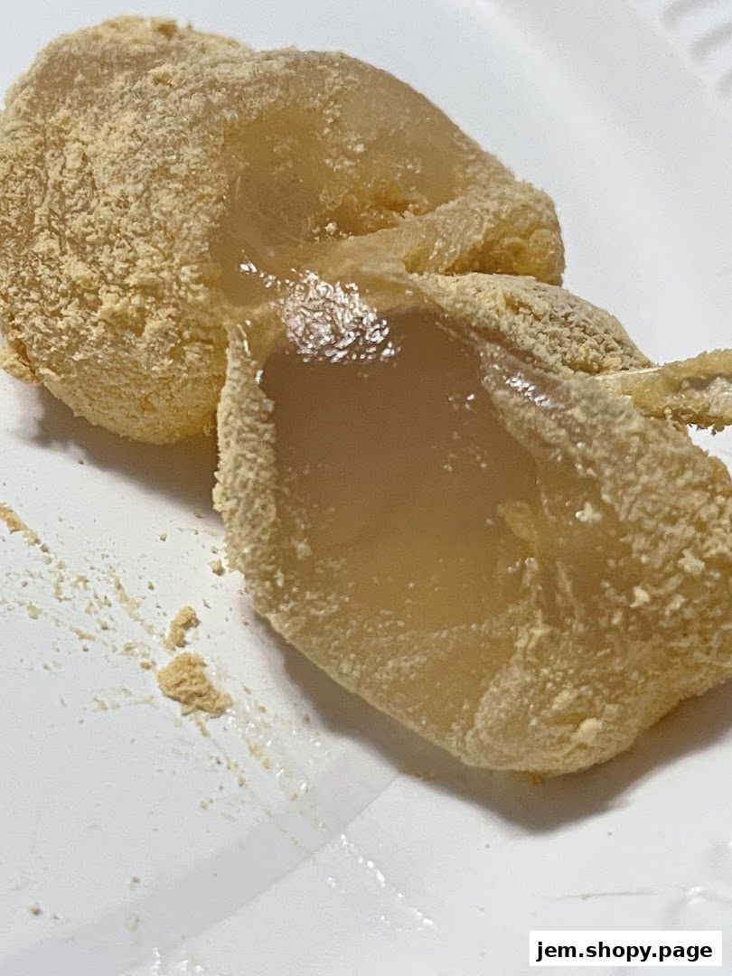 Close-up of Warabimochi dusted with kinako powder on a white plate.