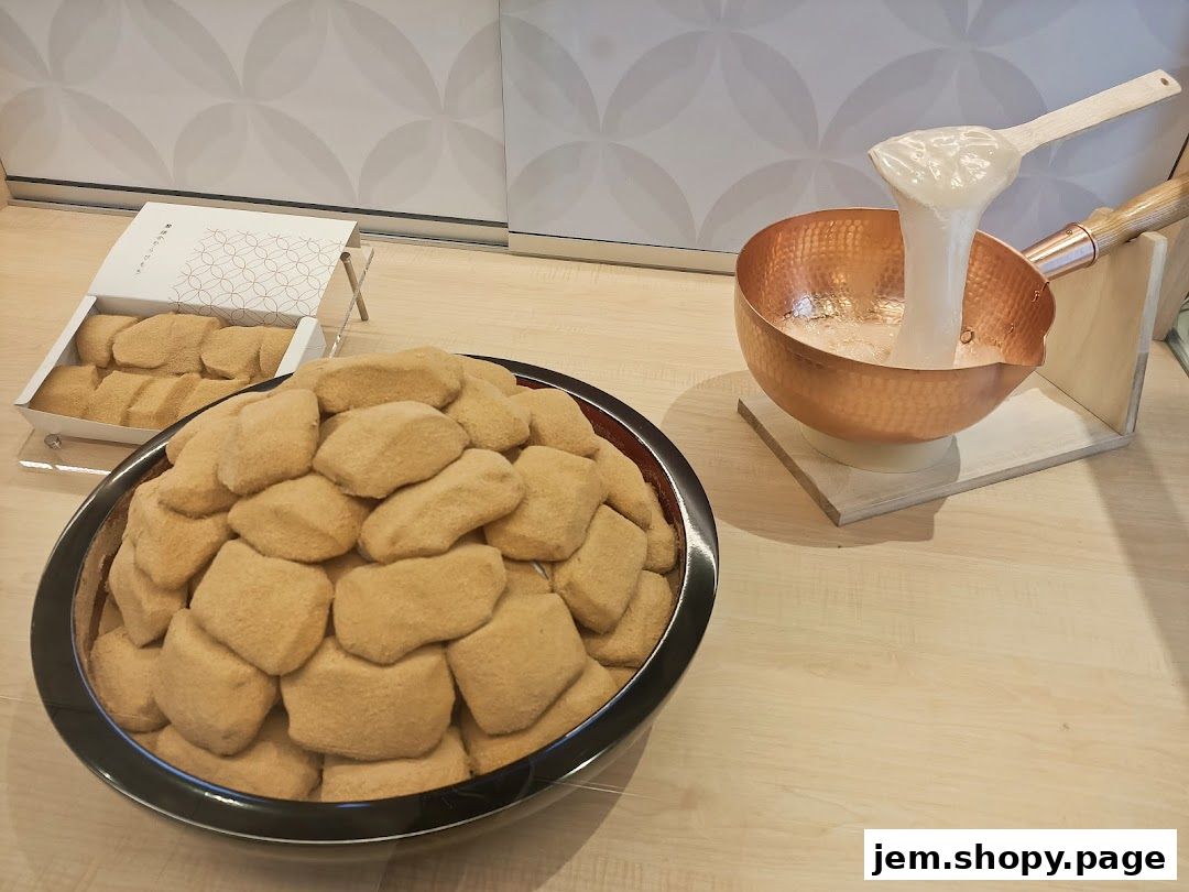 A display of freshly made warabimochi covered in kinako powder, with a demonstration of mochi preparation.