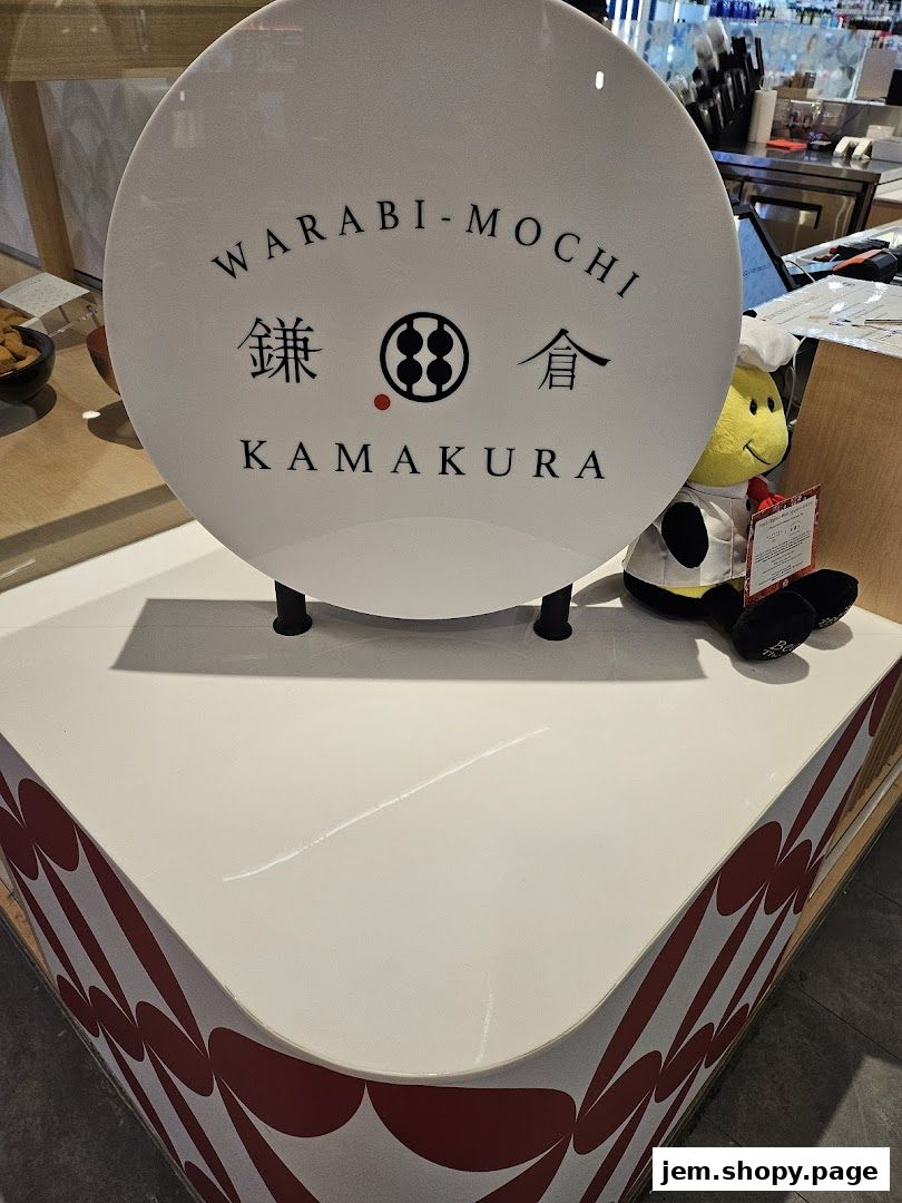 A sign for Warabi-Mochi Kamakura with a bee mascot wearing a chef's hat.