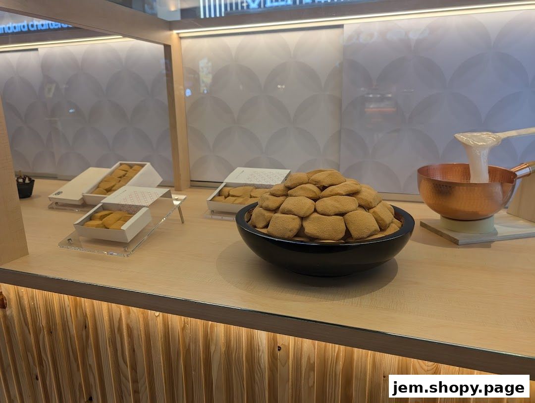 A display of Warabimochi in boxes and a bowl, with a copper pot showing mochi preparation.