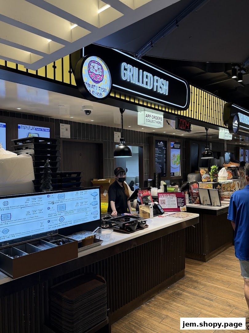 A food stall counter with a menu display and staff serving customers.