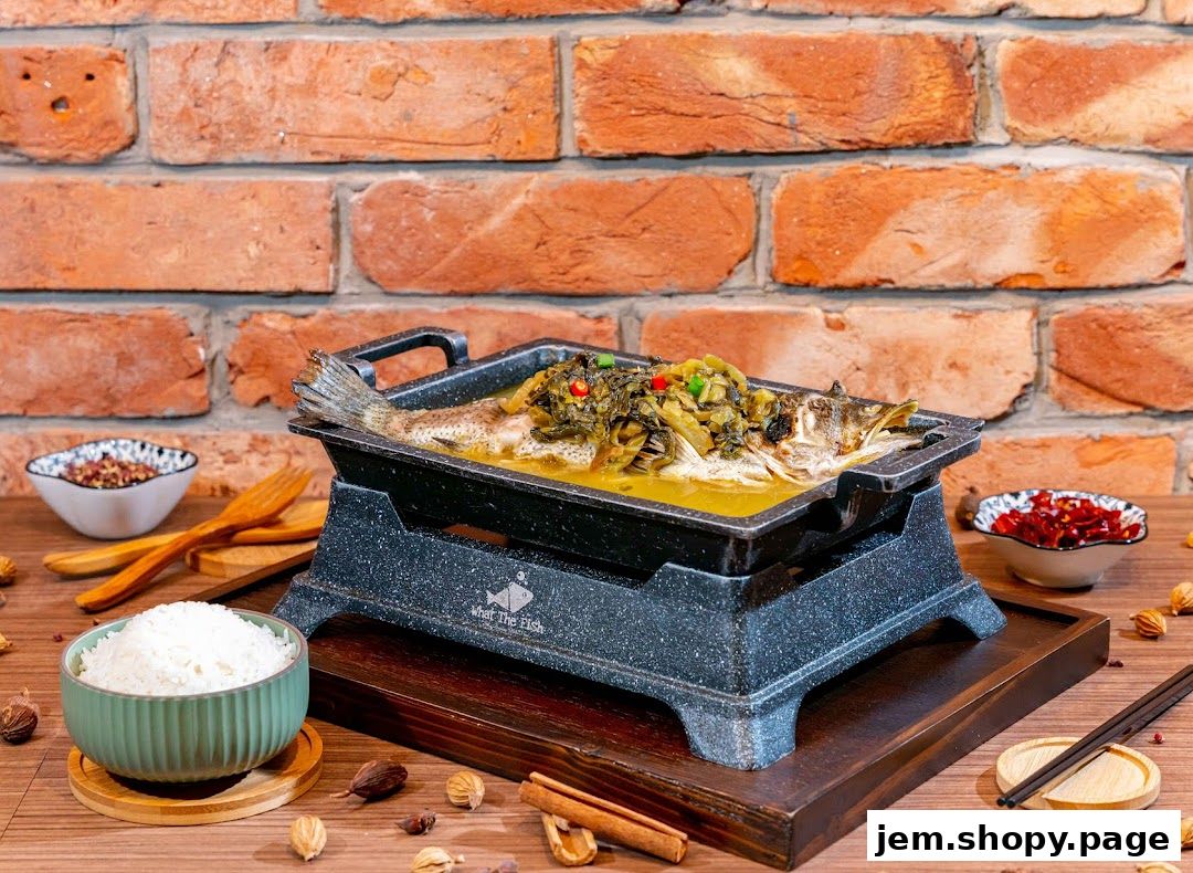A whole fish dish served in a hot pot with rice and spices against a brick wall.