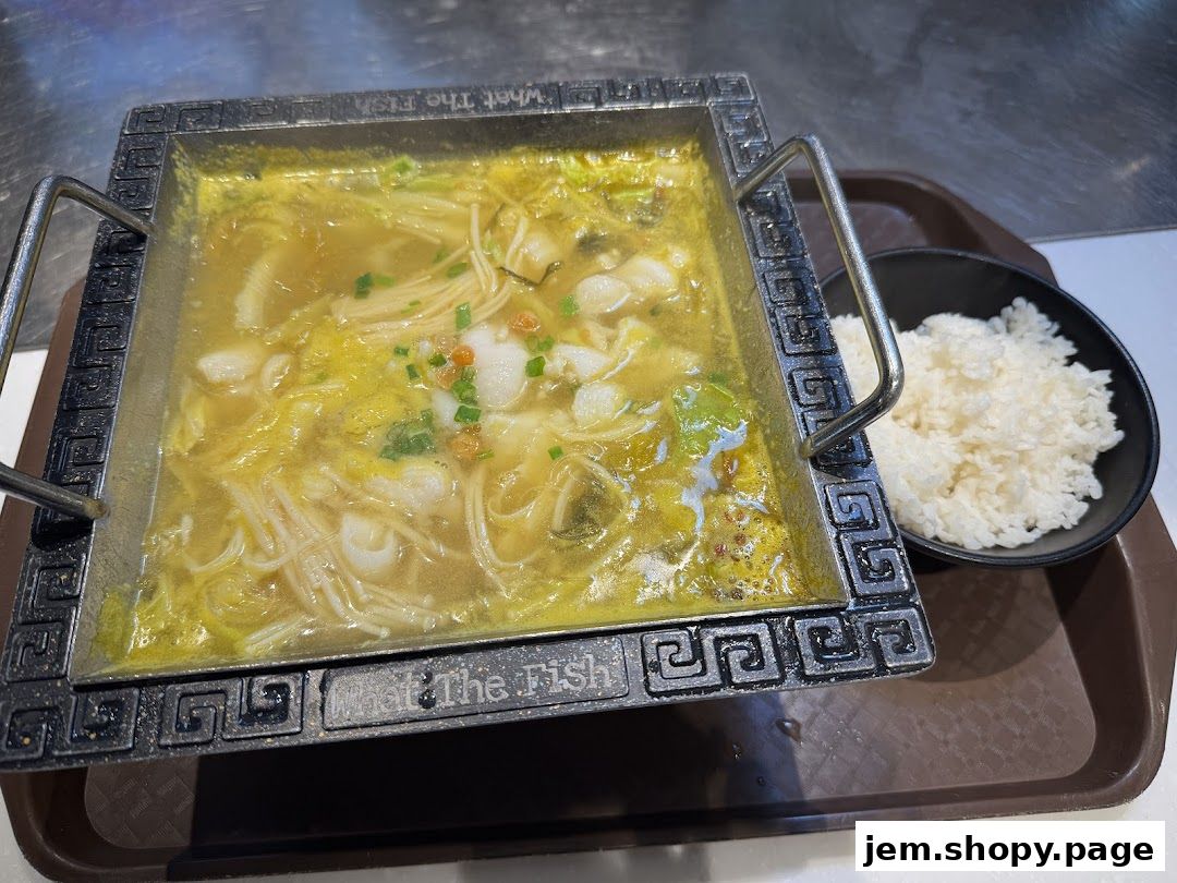 A hot pot dish with fish, enoki mushrooms, and vegetables, served with a side of rice.