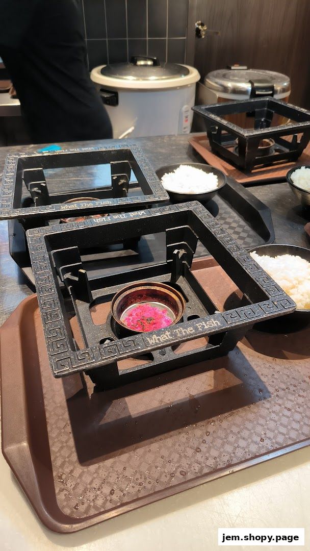 Table setting with portable stoves and bowls of rice at What The Fish restaurant.