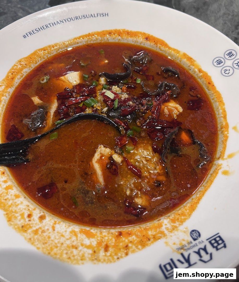 A close-up of a spicy fish dish in a white bowl with Chinese characters and a hashtag.
