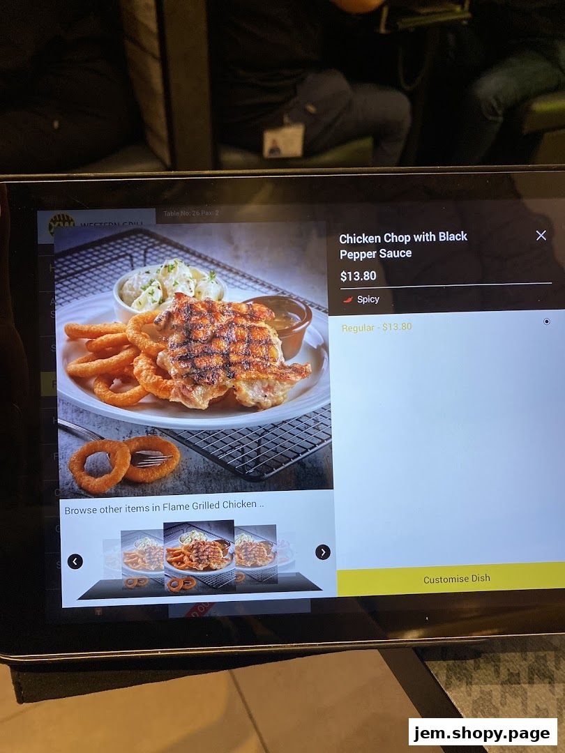 A digital menu displays a chicken chop with black pepper sauce and onion rings.