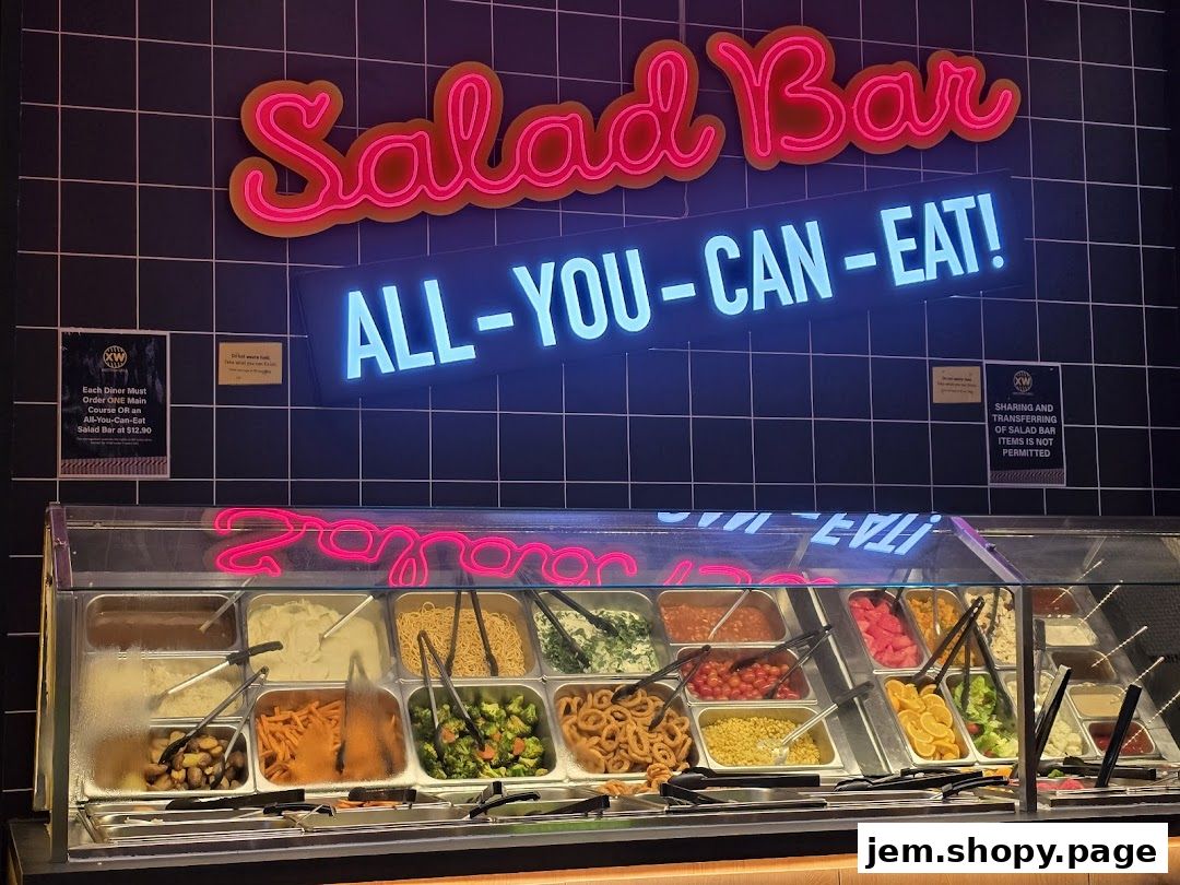 A vibrant salad bar with various fresh ingredients and a neon 'Salad Bar ALL-YOU-CAN-EAT!' sign.
