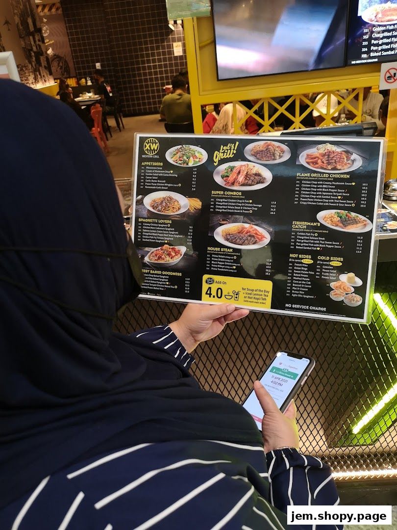 A person holds a menu from XW Western Grill, showcasing various dishes and prices.