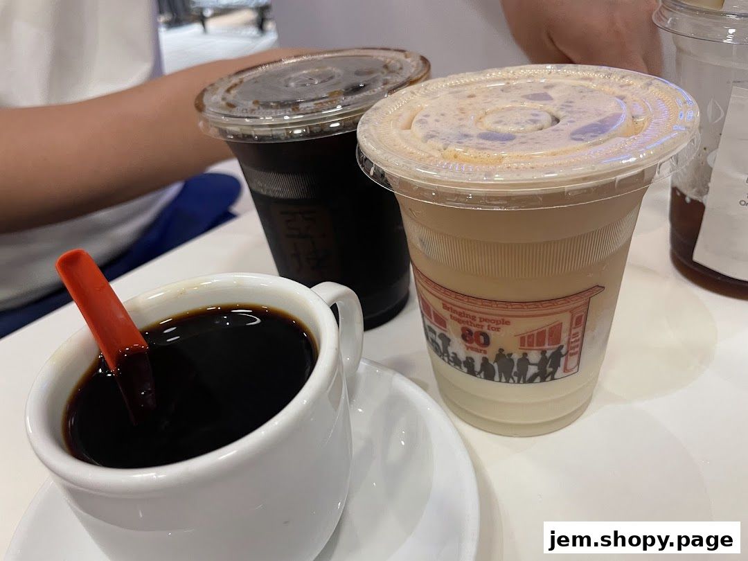 A close-up of three drinks from Ya Kun Kaya Toast, including coffee and a milky beverage.