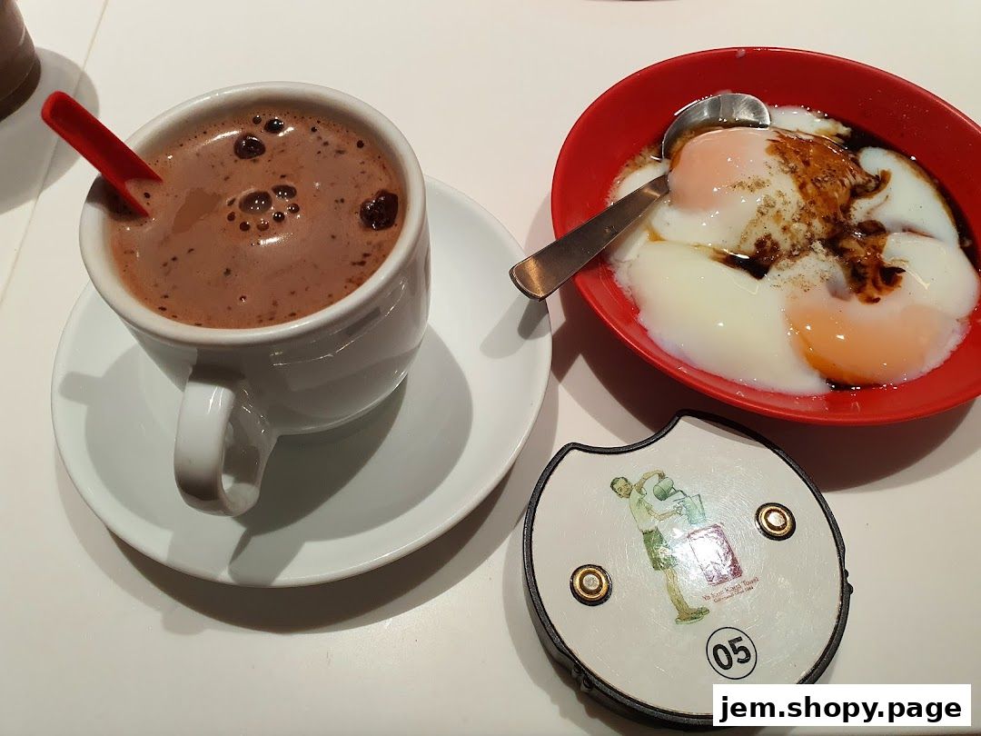 A cup of hot chocolate and soft-boiled eggs with soy sauce and pepper.