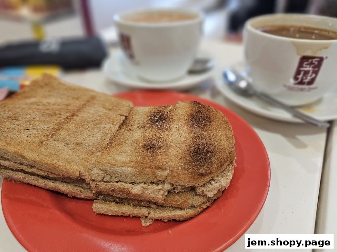 A close-up of kaya toast and two cups of coffee on a table.