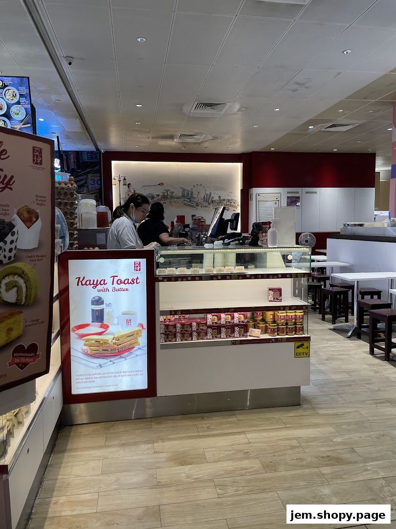 Interior view of Ya Kun Kaya Toast with staff behind the counter and display shelves.