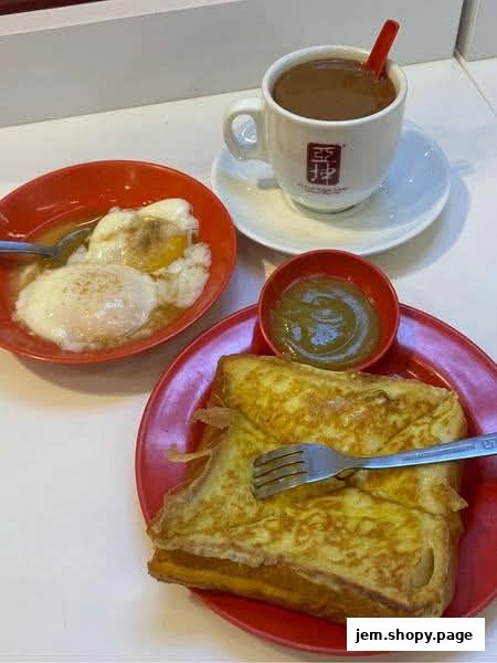 A delicious breakfast spread featuring soft-boiled eggs, kaya toast, and a cup of coffee.