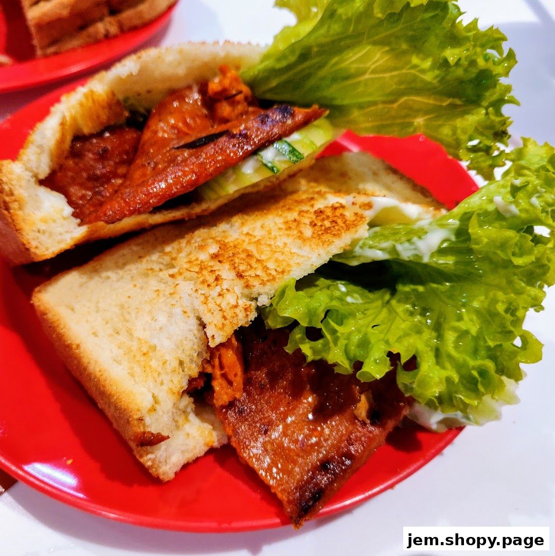 A close-up shot of a delicious kaya toast sandwich with lettuce and cucumber on a red plate.