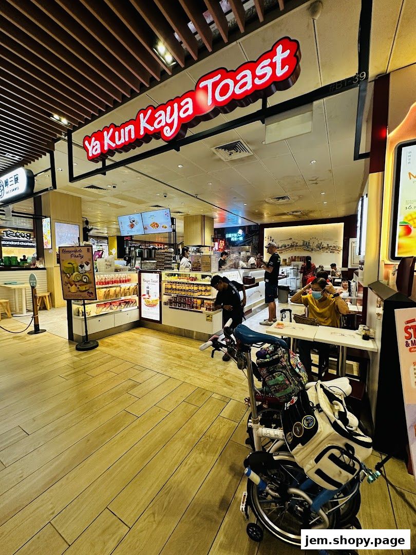 The exterior of Ya Kun Kaya Toast shop with its prominent signage and display of pastries.