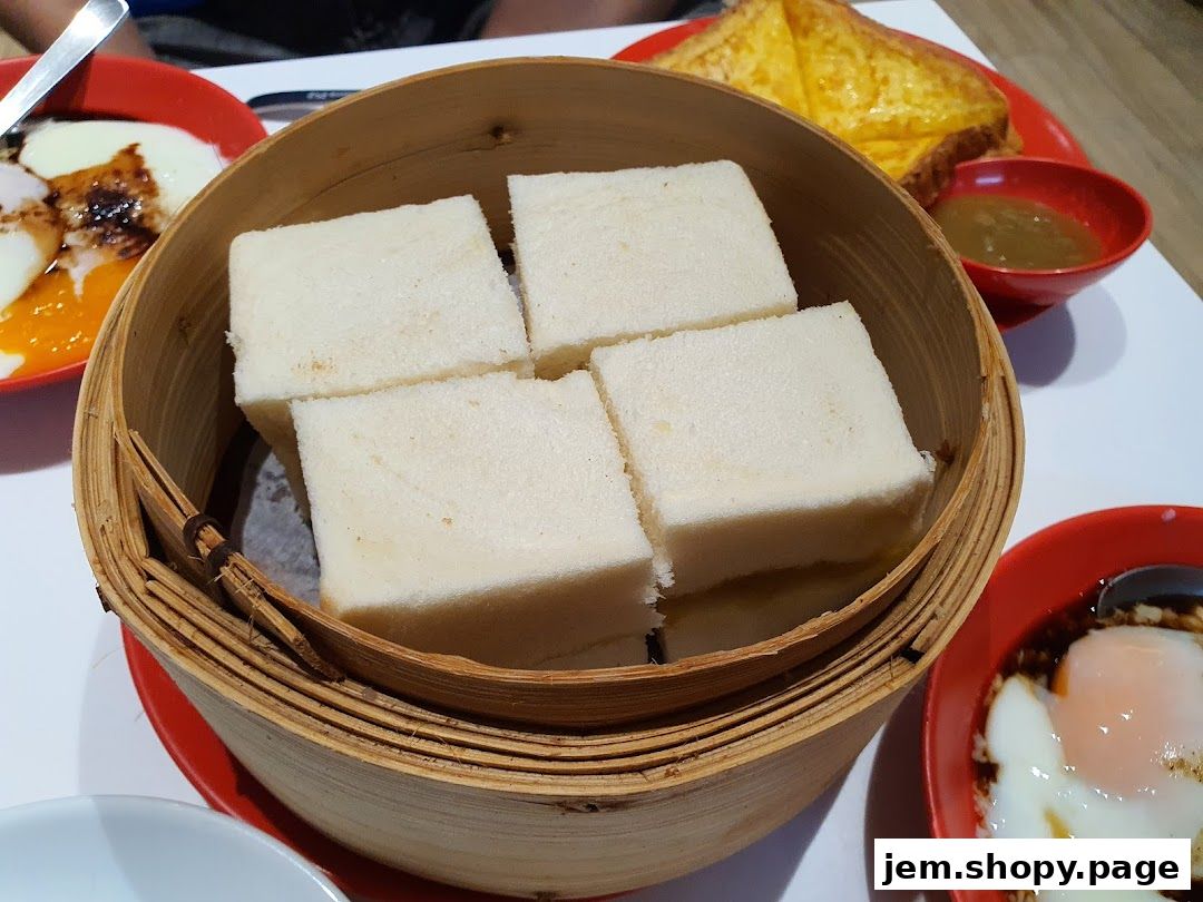 A close-up of steamed bread slices served with soft-boiled eggs and kaya.