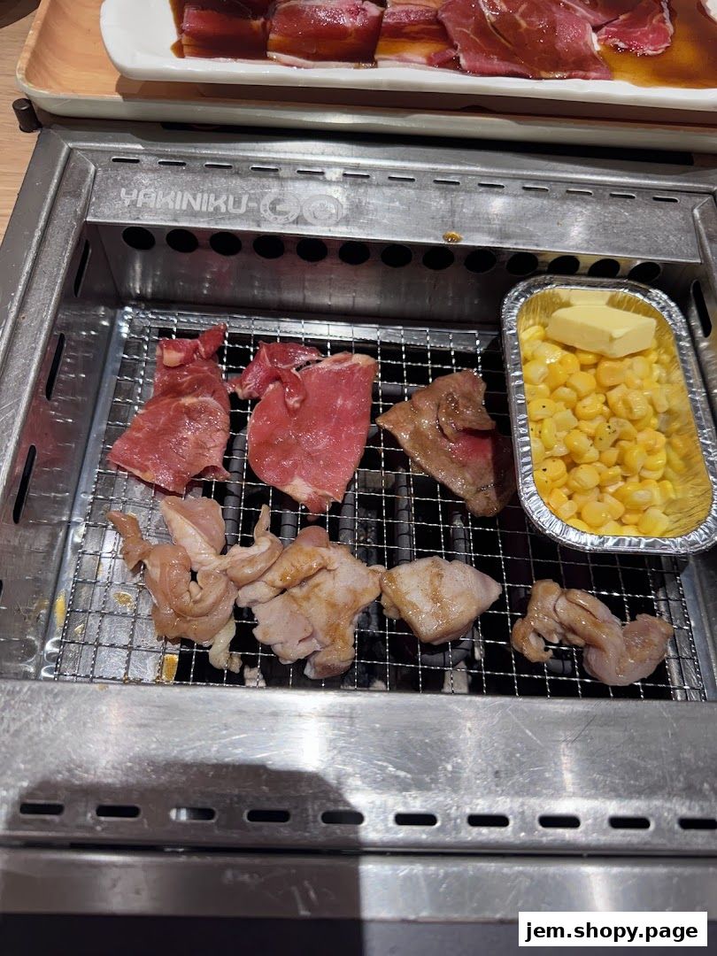 Assortment of raw meats and corn with butter grilling on a Yakiniku grill.