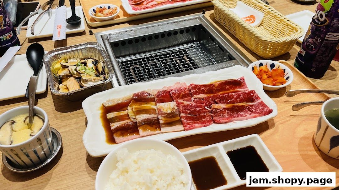 A table laden with delicious Yakiniku dishes, including marinated meats, steamed egg, and rice.