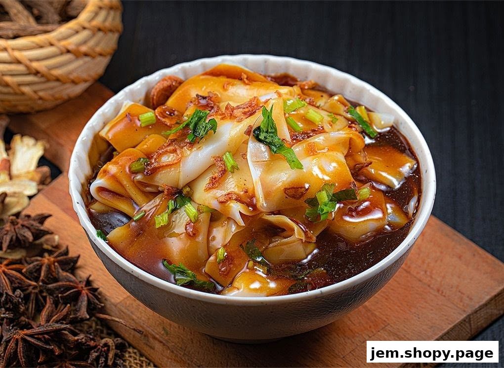 A close-up of a bowl of wide rice noodles in a savory dark sauce, garnished with scallions.