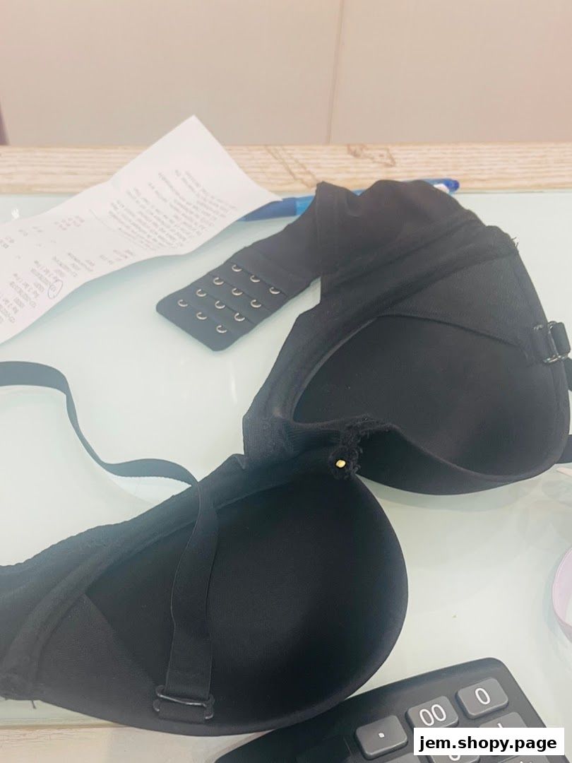 A black bra, receipt, and calculator are on a table.