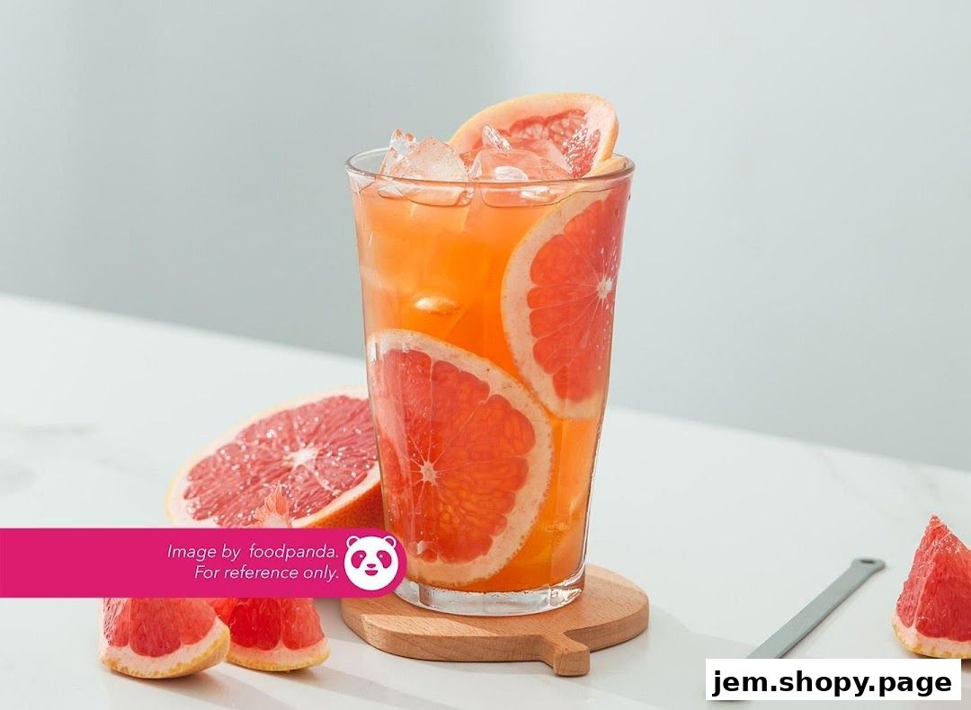 A refreshing grapefruit drink with ice and fresh grapefruit slices.
