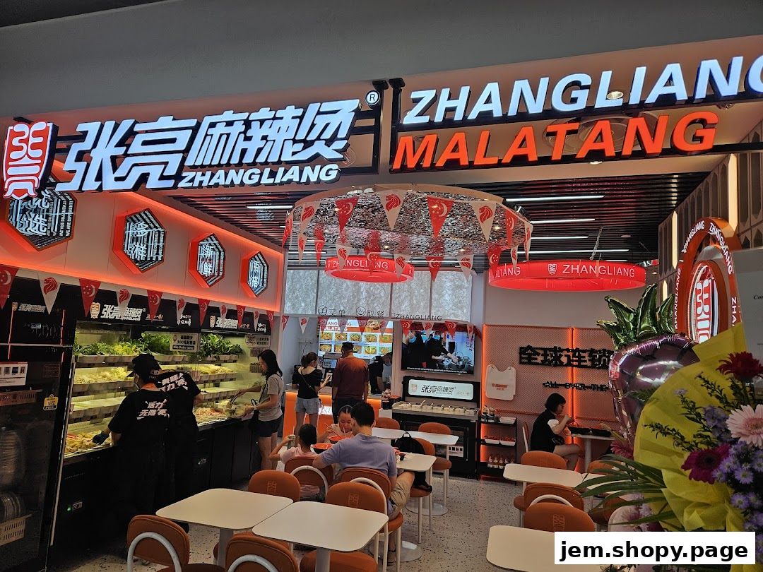 Interior view of Zhangliang Malatang restaurant with customers and food displays.