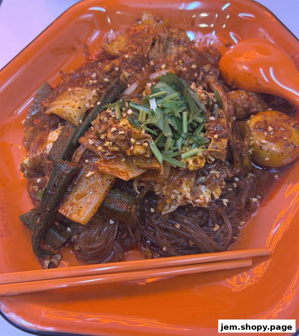 A close-up shot of a spicy malatang dish with noodles, vegetables, and egg.