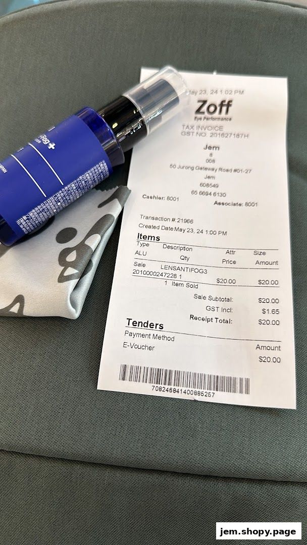 A bottle of lens cleaner and a cleaning cloth next to a Zoff tax invoice.
