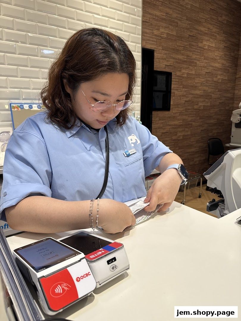 A shop assistant at Zoff Jem is processing a payment with a card reader.