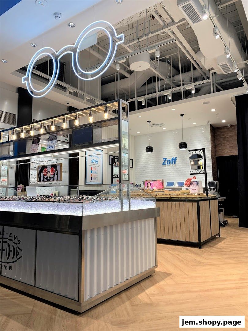 Interior of a modern eyewear store with a large neon glasses sign and display cases.