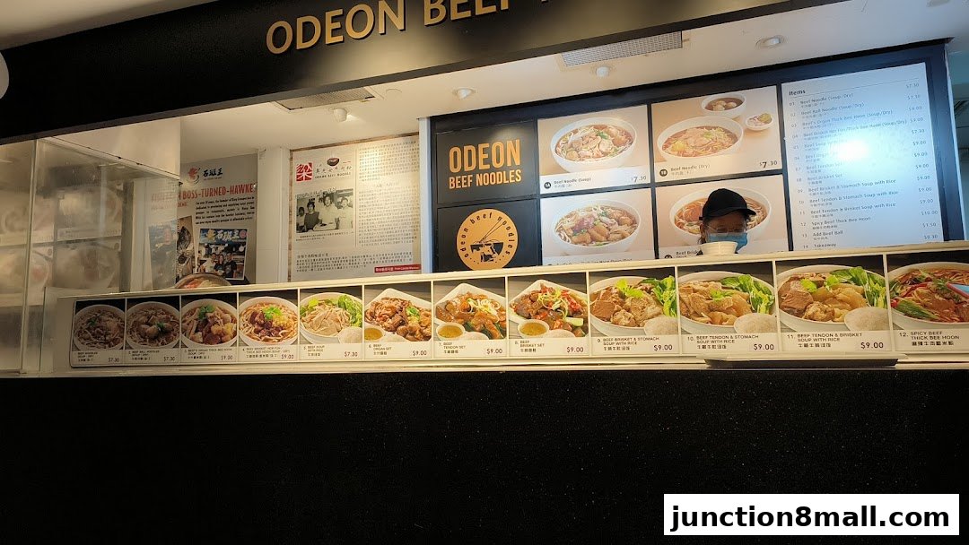 A food stall display featuring various beef noodle dishes with prices and images.