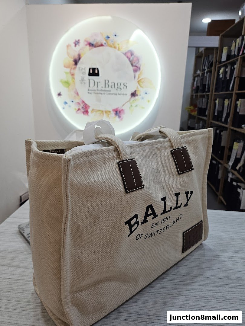 A canvas tote bag with 'BALLY' logo is displayed in front of the Dr. Bags shop sign.