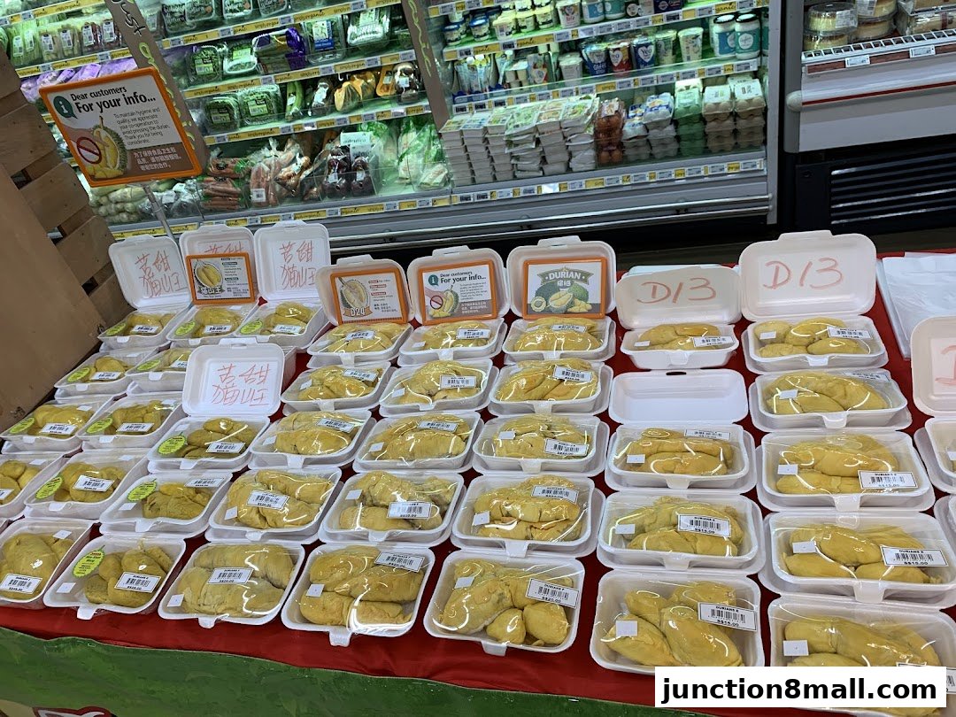 A display of pre-packaged durian fruits in white containers at a FairPrice Finest supermarket.