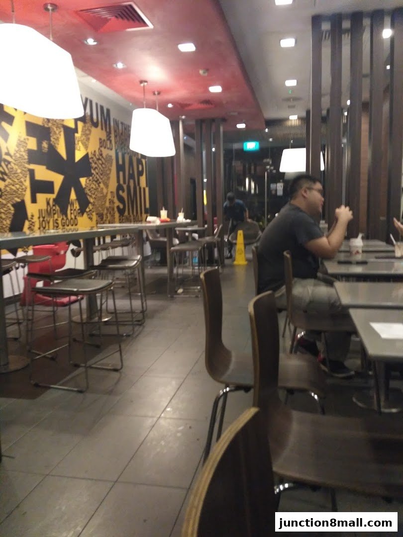Interior view of a McDonald's restaurant with seating and customers.