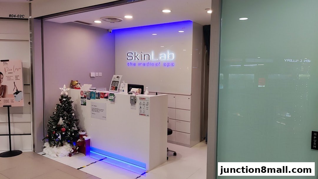 The reception area of SkinLab, a medical spa, with a Christmas tree and a glowing sign.