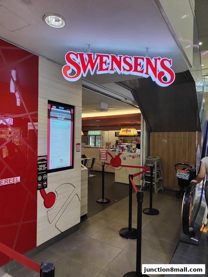 The entrance to Swensen's Junction 8 with a digital display and queue barriers.