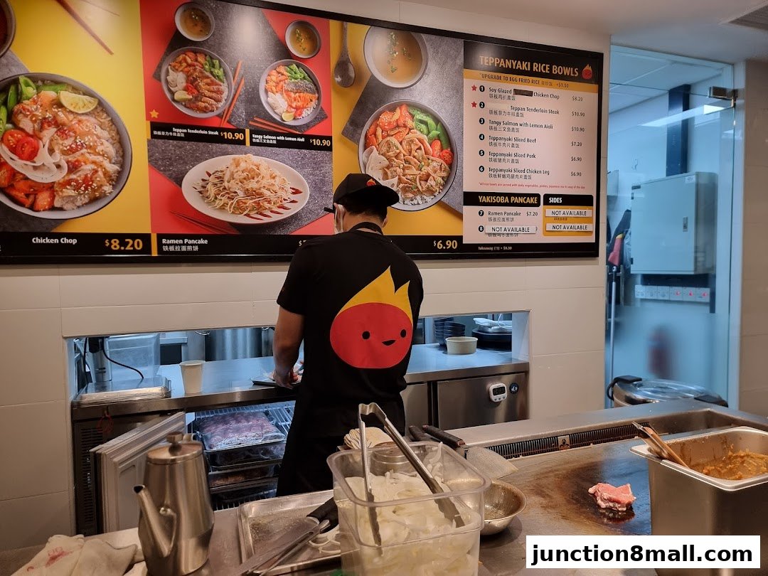 A chef stands in front of a menu displaying teppanyaki rice bowls and yakisoba pancakes.