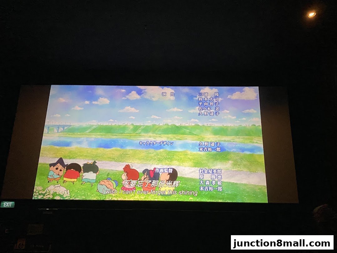 A movie screen displaying animated characters and credits with a scenic background.