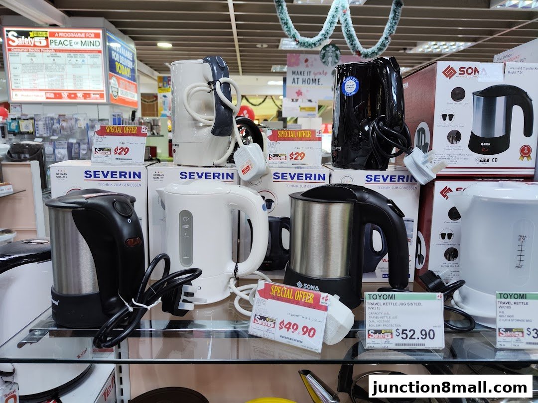 A display of various electric kettles and travel appliances with special offer price tags.