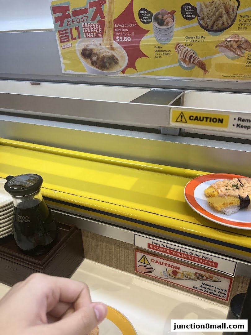 A conveyor belt sushi restaurant with various sushi dishes and menu items displayed.