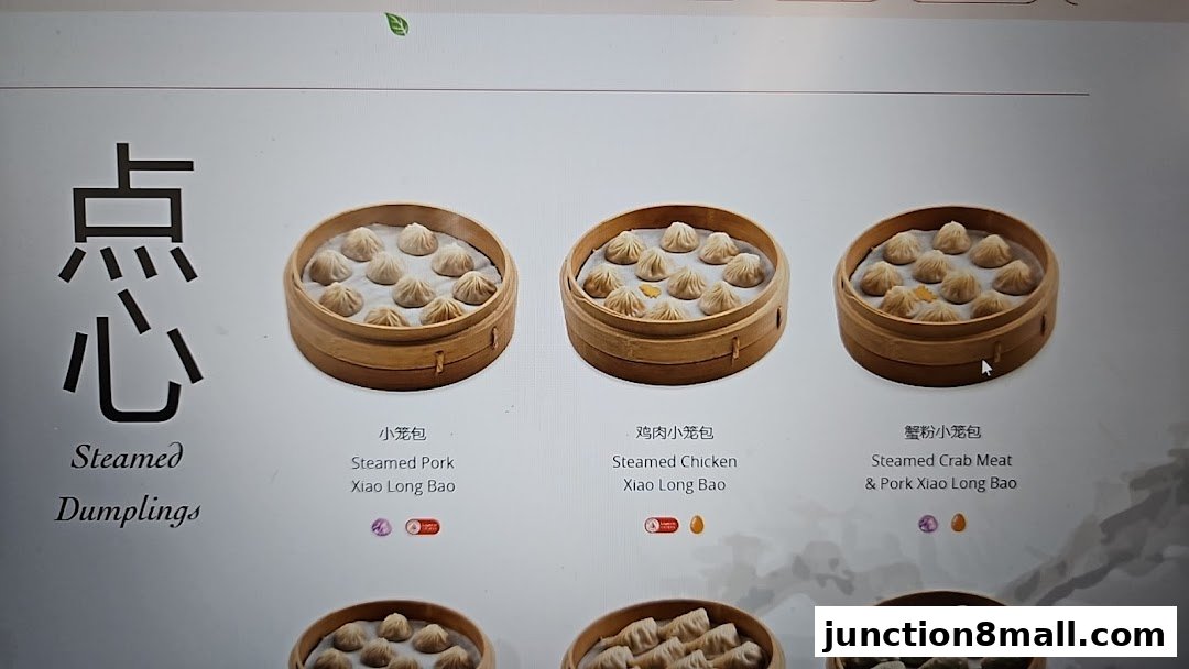 A menu display featuring various types of steamed dumplings, specifically Xiao Long Bao.